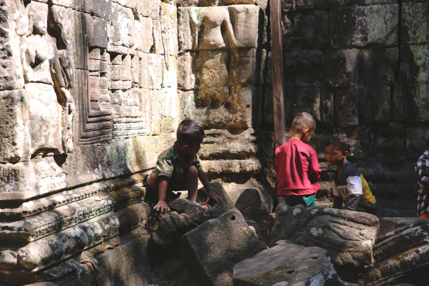 Kids playing on the stones of Ta Som
