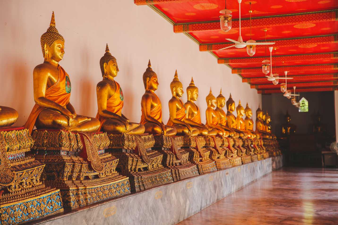 Golden buddhas lining the hallway
